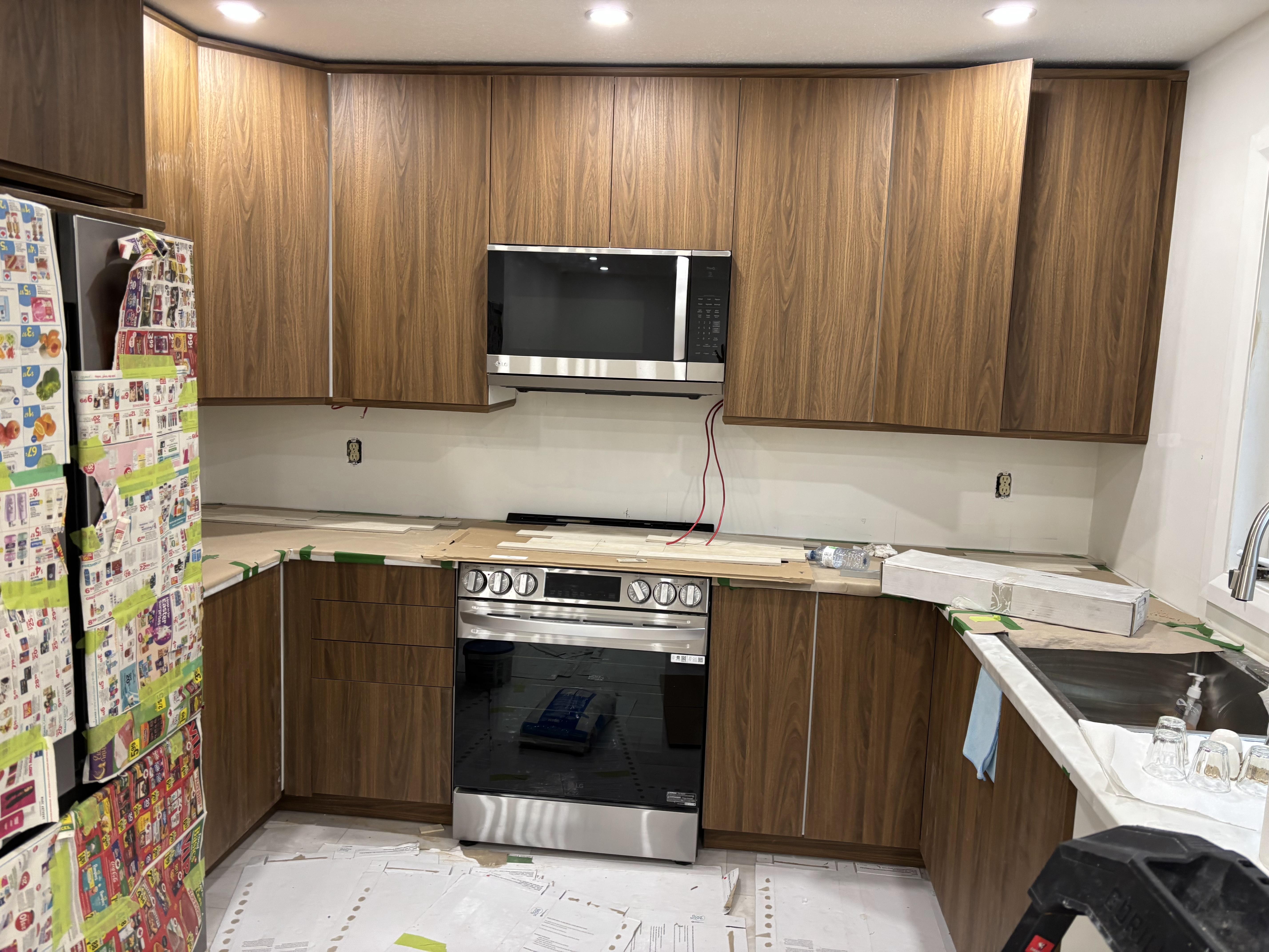 Cabinet installation by 613Pro - painter spraying cabinets in updated kitchen